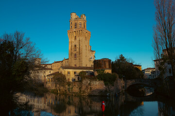 Fototapeta na wymiar Historic center of the city of Padua. The Specola seen from the canal. Particular warm light, artistic image.