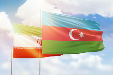 Sunny blue sky and flags of azerbaijan and iran