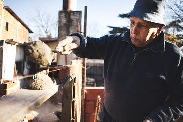 Mason raising wall places mixture on wood