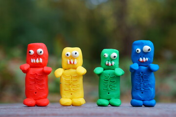 Figures of colorful zombies in close-up. Funny toy monsters made of plasticine.