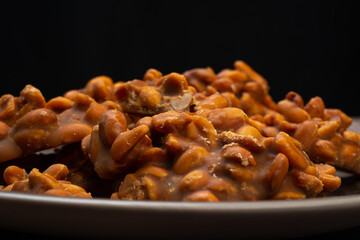 Peanut candy served in a brown silver on wooden background.