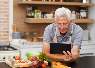 If only I could remember how to use this thing. Shot of a handsome senior man watching a tablet...