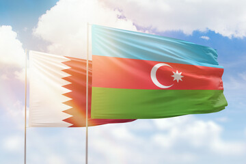 Sunny blue sky and flags of azerbaijan and qatar