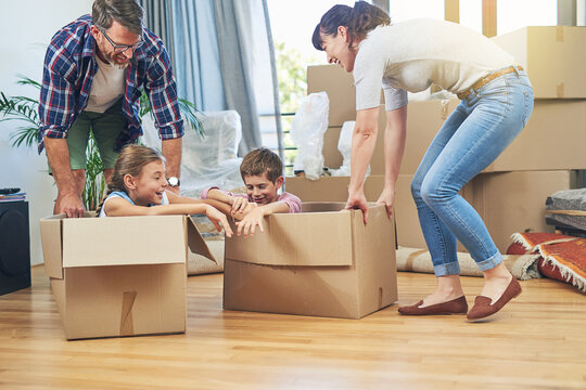 Making Moving Day A Family Friendly Activity. Shot Of A Happy Family Having Fun Together On Moving Day.