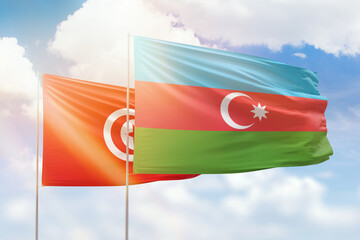 Sunny blue sky and flags of azerbaijan and tunisia