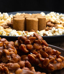 June party: Peanut candy, popcorn, peanuts and paçoca on rustic wooden background