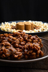 June party: Peanut candy, popcorn, peanuts and paçoca on rustic wooden background