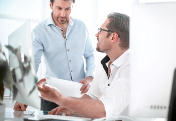 Obraz premium Two serious businessmen talking and working in the office