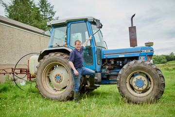 Come take a look in my office. Portrait of a cheerful young farmer posing next to his large farm...