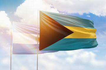Sunny blue sky and flags of bahamas and argentina