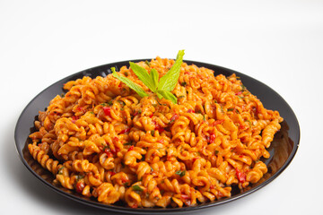 auger pasta on black plate on white background
