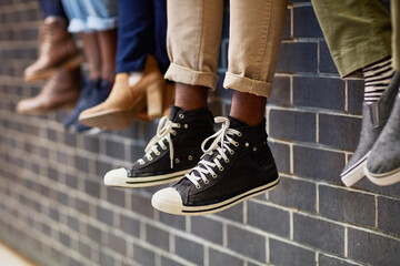 The wall is where we like to chill out. Closeup shot of an unidentifiable group of university...