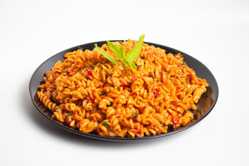 auger pasta on black plate on white background