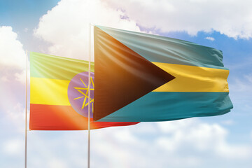 Sunny blue sky and flags of bahamas and ethiopia
