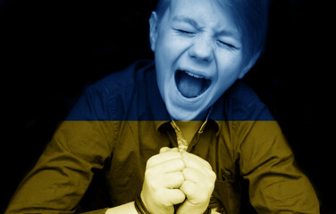 A child tonned with the flag of Ukraine is crying. Sadness longing hope. Tear macro. Children's...