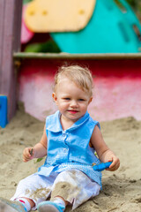 Girl playing with toys in the sandbox in the yard