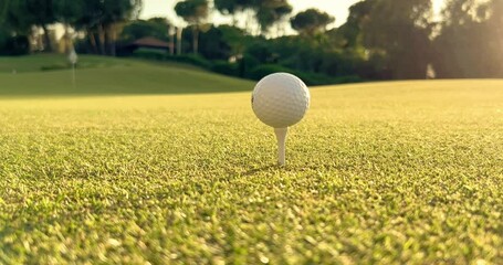 Golfer placing golf ball on the tee at golf course before shot