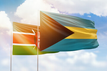 Sunny blue sky and flags of bahamas and kenya