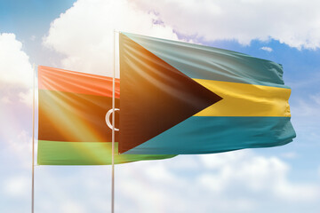 Sunny blue sky and flags of bahamas and libya