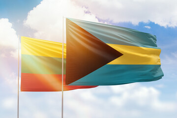 Sunny blue sky and flags of bahamas and lithuania