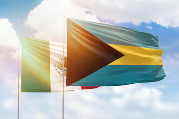 Sunny blue sky and flags of bahamas and mexico