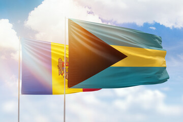 Sunny blue sky and flags of bahamas and moldova