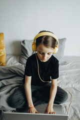 A girl studies at a laptop at home In the bed