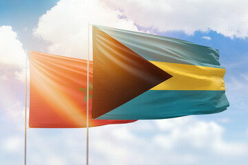 Sunny blue sky and flags of bahamas and morocco