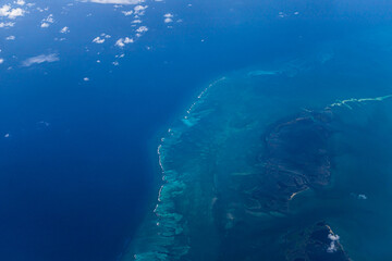 Aerial view of blue ocean and underwater landmarks with a few clouds