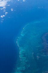 Fototapeta na wymiar Aerial view of blue ocean and underwater landmarks with a few clouds