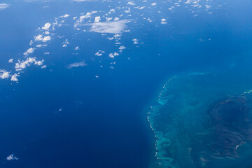 Aerial view of blue ocean and underwater landmarks with a few clouds