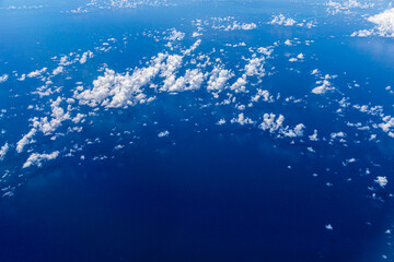 Aerial view of blue ocean with clouds and reflection