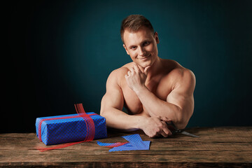 sports man gives a gift on a dark background