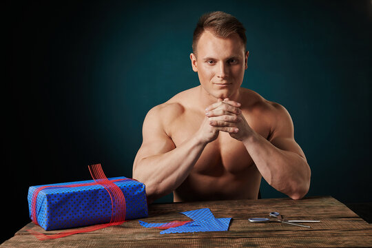 sports man gives a gift on a dark background