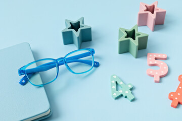 Child eyeglasses over pastel  background. Optical store, glasses selection for kids, eye test, vision examination at optician concept. Top view, flat lay