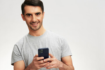 portrait man in a gray t-shirt with a phone communication technology isolated background