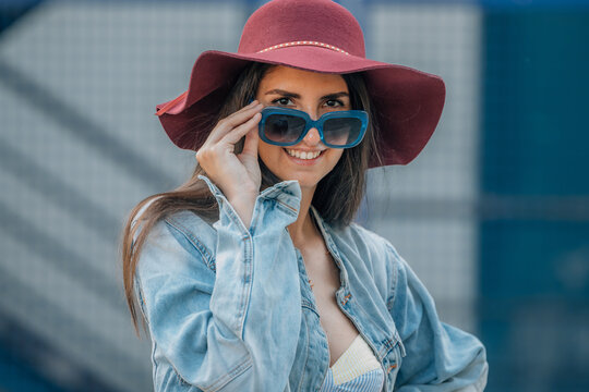 urban hipster girl in hat and sunglasses in summer on the street