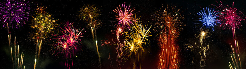 Fototapeta premium HAPPY NEW YEAR - New Year's Eve, Silvester 2023 holiday background banner panorama long greeting card - Colorful firework fireworks oon dark night sky..
