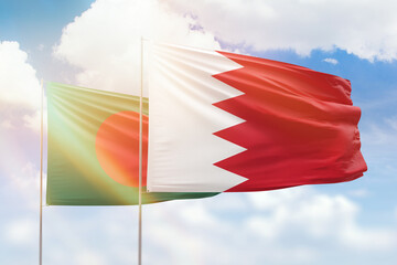 Sunny blue sky and flags of bahrain and bangladesh