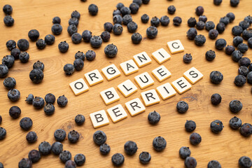 healthy organic blueberries letters on wood background
