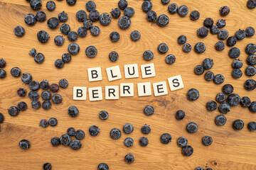 healthy organic blueberries letters on wood background