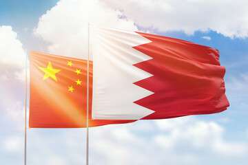 Sunny blue sky and flags of bahrain and china