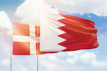 Sunny blue sky and flags of bahrain and denmark