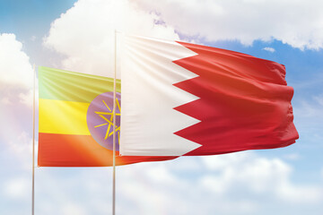 Sunny blue sky and flags of bahrain and ethiopia