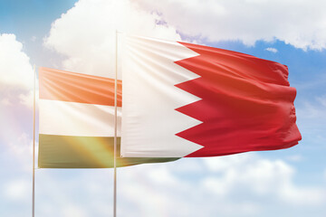 Sunny blue sky and flags of bahrain and hungary