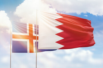 Sunny blue sky and flags of bahrain and iceland