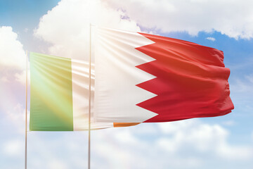 Sunny blue sky and flags of bahrain and ireland
