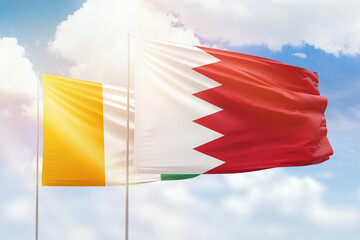 Sunny blue sky and flags of bahrain and ivory coast