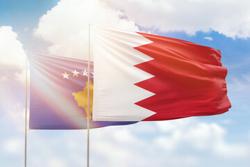 Sunny blue sky and flags of bahrain and kosovo