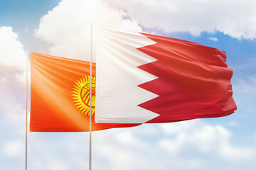 Sunny blue sky and flags of bahrain and kyrgyzstan
